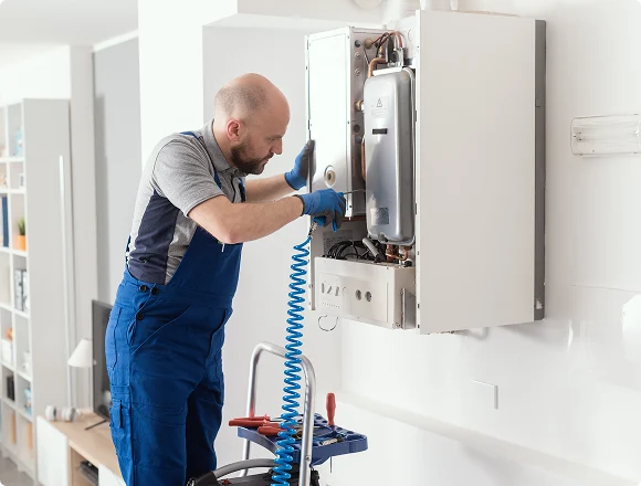 Technician servicing a wall-mounted boiler heating system