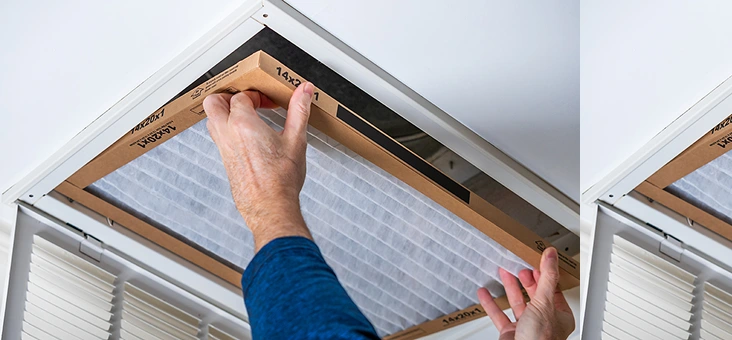 A person in a blue sleeve replaces a rectangular air filter in a ceiling vent, emphasizing home maintenance and air quality improvement.
