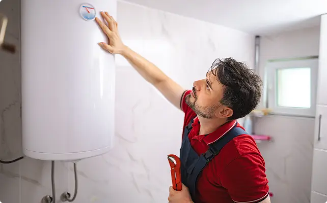Technician checking a water heater with a wrench.