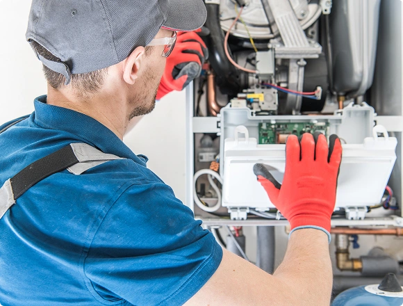 HVAC technician inspecting the internal components of a gas boiler during maintenance