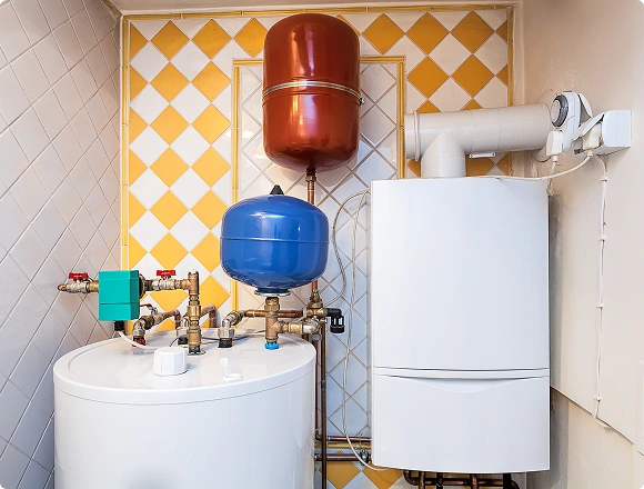 Residential heating system with gas boiler, hot water tank, and expansion tanks installed in a utility room