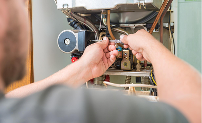 Technician connecting electrical wires inside a boiler or heating unit.