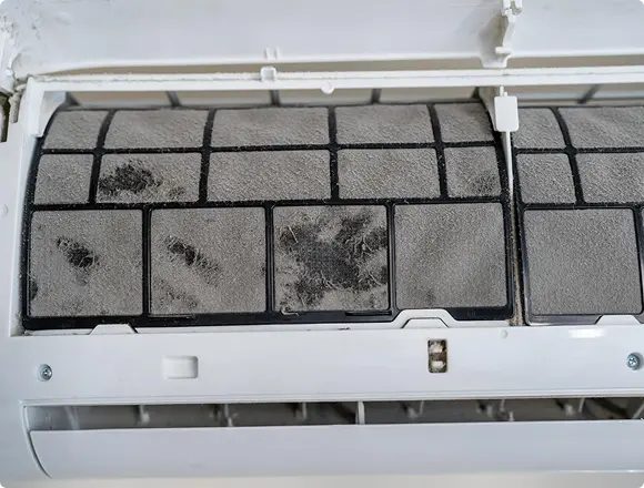 Air conditioner filter covered with dust and dirt, indicating the need for cleaning or maintenance.