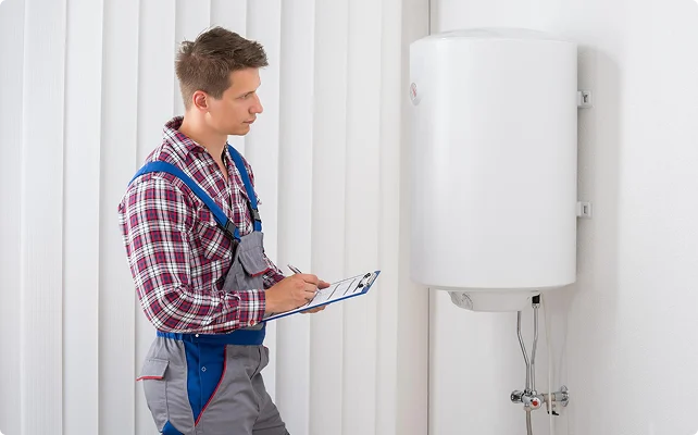 Technician inspecting a wall-mounted water heater